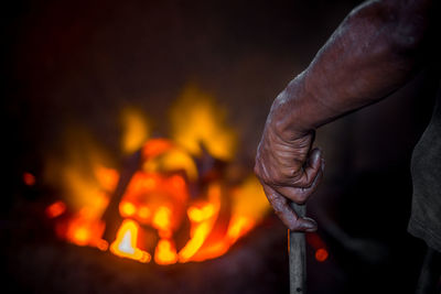 Close-up of hand holding bonfire at night