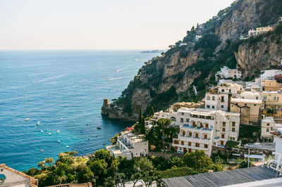 High angle view of buildings and rocky mountains by sea at positano