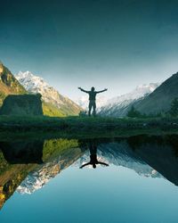 Man standing by lake against clear sky