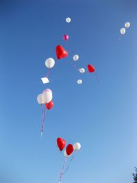 Low angle view of balloons against sky