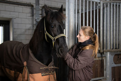 Woman with horse in stable