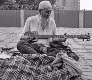 Full length of man sitting on guitar