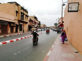 People riding motorcycle on road against sky