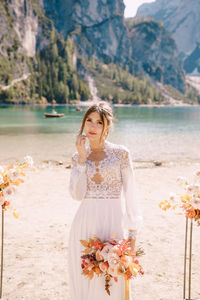 Woman standing on beach by sea