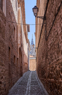 Narrow alley amidst buildings against sky