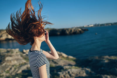 Woman standing in sea against sky