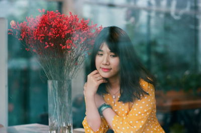 Portrait of beautiful woman with red flower