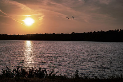 Scenic view of lake against sky during sunset