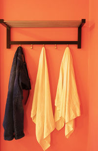 Clothes drying on clothesline against orange wall