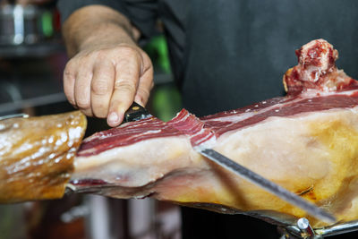 Specialist person cutting iberian ham