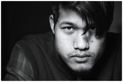 Close-up portrait of young man sitting at home