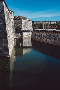 Arch bridge over river against buildings