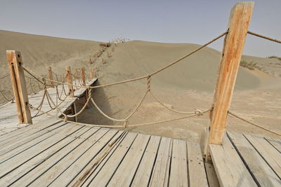 Wooden posts on desert against sky