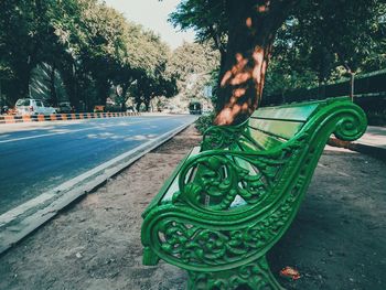 Empty bench by street in park