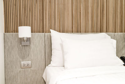 Electric lamp hanging by bed at hotel