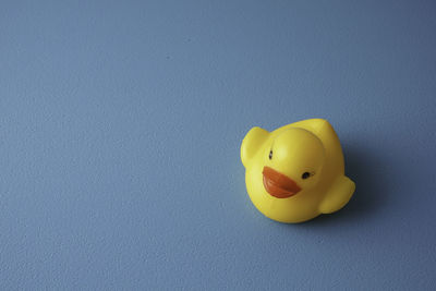 Close-up of yellow toy over blue background