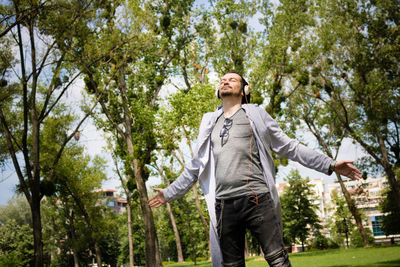 Low angle view of man standing against trees