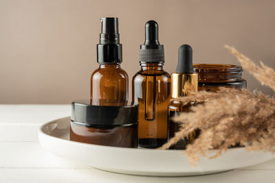 Dark amber glass dropper bottles mockup. natural organic essential oil packaging design. dry flowers