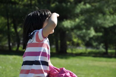 Side view of girl sitting on field