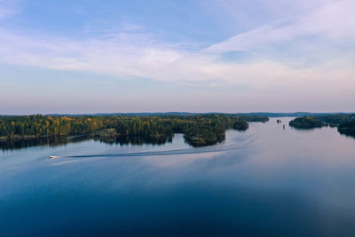 Scenic view of lake against sky and a speedboat 