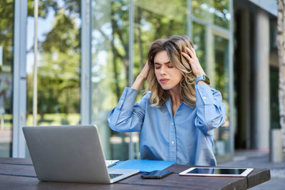 Businesswoman using laptop while sitting on table