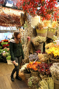 Full length of woman looking at flower shop