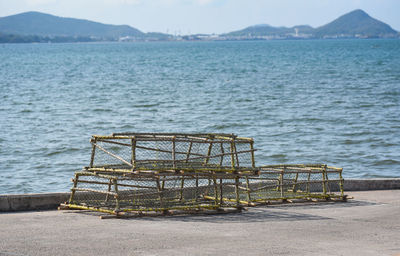 Abandoned boat by sea against mountain