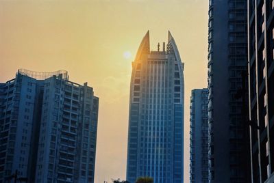 Low angle view of buildings against sky during sunset