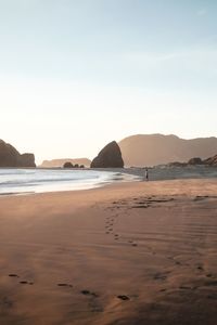 View of boy standing at beach against sky