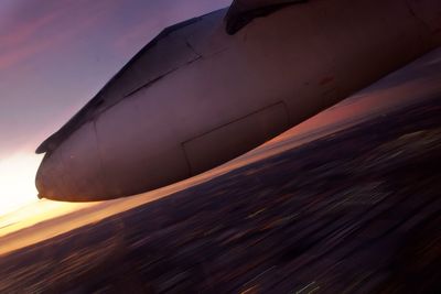 Close-up of airplane flying over sea against sky