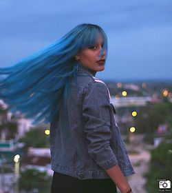 Young woman standing against sky at night