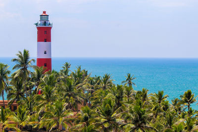 Lighthouse by sea against sky