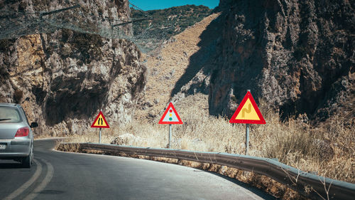 Road sign by rock formation