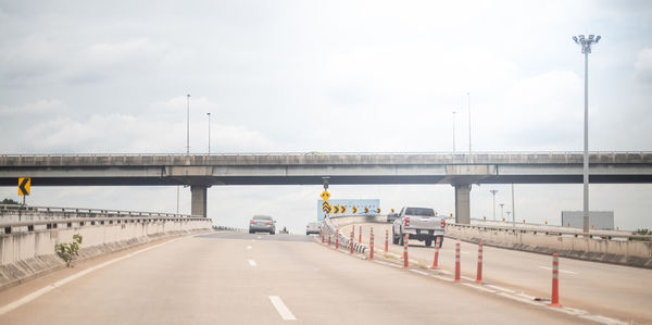 Bridge over road against sky in city