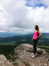 Full length of woman standing on mountain against sky