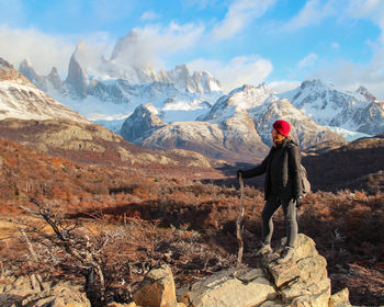 Rear view of woman walking on mountain against sky