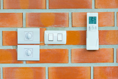 Full frame shot of brick wall. close-up of power switches and air conditioning control on wall