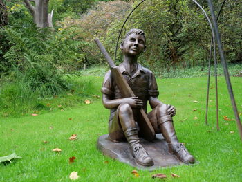 Statue of man sitting in park