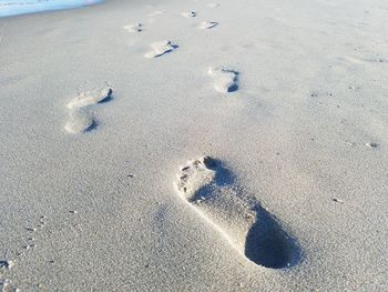 High angle view of footprints on sand at beach