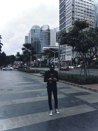 Full length rear view of man standing on street against buildings