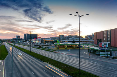 View of city street against sky during sunset