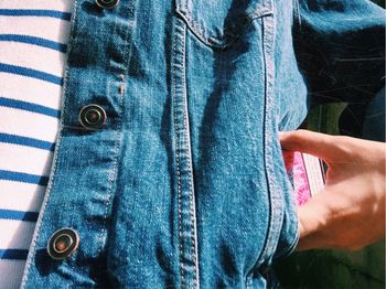 Cropped image of woman putting mobile in pocket