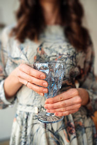 Midsection of woman drinking glass