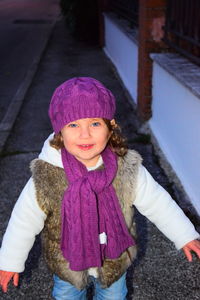 Portrait of cute girl standing on sidewalk