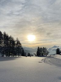 Scenic view of snow covered landscape against sky during sunset