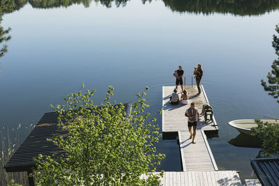 Group of friends with babies standing on deck at lake