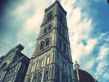 Low angle view of tower against cloudy sky