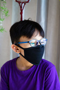 Close-up of girl wearing mask looking away