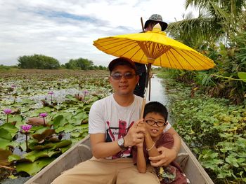 Portrait of father and son sitting in boat