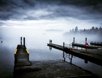 Pier on lake against sky during winter